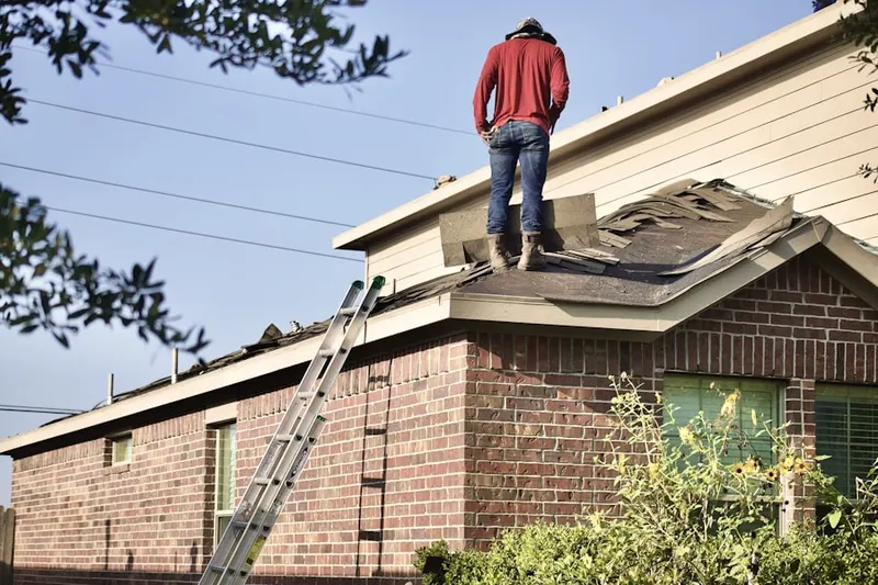 Professional roofer working on a residential roof in Post Corner